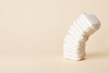 Plain white diapers stacked against a light cream background